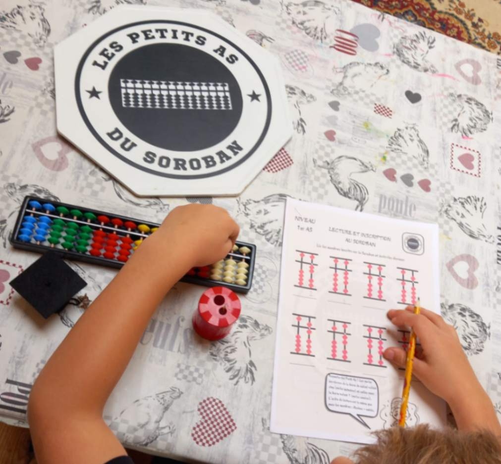 Enfant de l'Imaginarium (Donnezac- 33820 Gironde) qui fait un exercice de soroban à Donnezac en Gironde (33820)