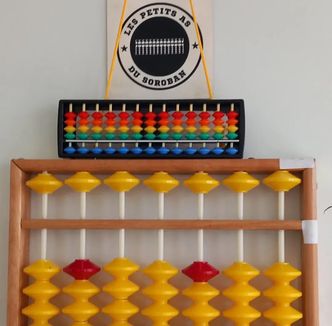 Image du tableau blanc de visio chez les petits as du soroban, avec 2 bouliers et le logo suspendu 